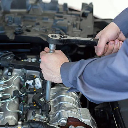 Mechanic using wrench on car engine